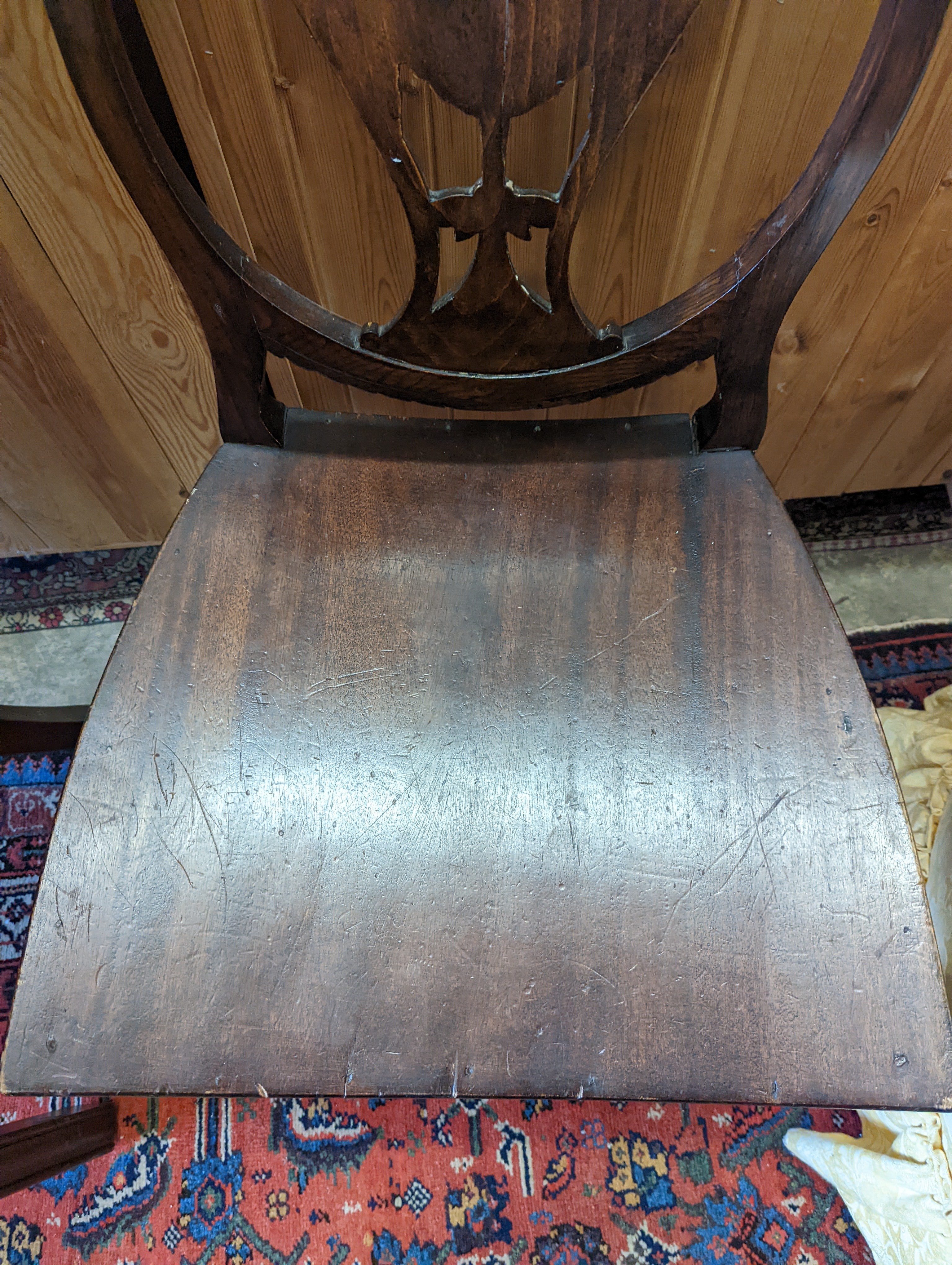 A brown leather upholstered desk chair, a mahogany hall chair and two upholstered armchairs